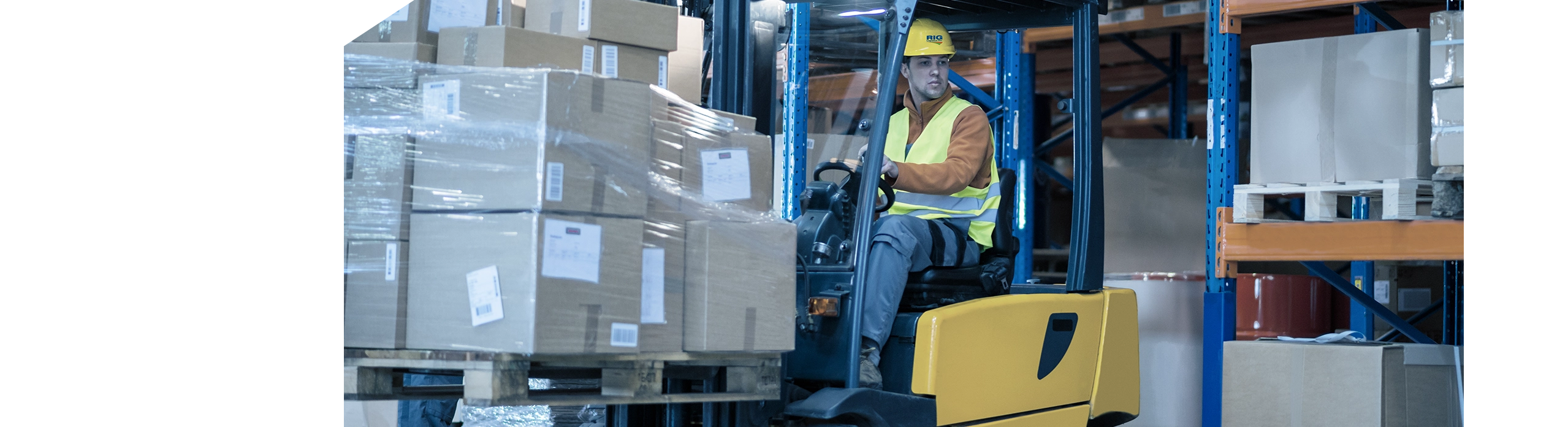 RIG Logistics warehousing employee operating forklift with pallet of packages